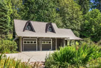 Here, we see the detached garage with studio space, as seen from the front path of the main home.The paved area is large enough to allow access to the garage as well as additional parking, if needed.