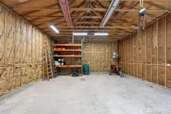 Oversized insulated garage/shop with shelving that conveys.