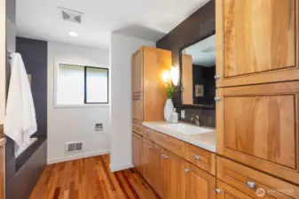 Hallway bath with soaking tub, divided toilet area, and plenty of storage