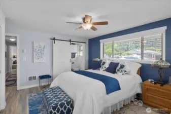 Primary bedroom with barn door entry leading to the adjoining bathroom.