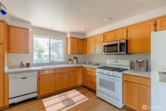 The spacious kitchen includes ample cabinetry. Virtually staged.