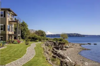 Relax and enjoy the scenic view of Rich Passage from the comfort of Adirondack chairs, creating a perfect spot to unwind and take in the natural beauty of the surroundings.
