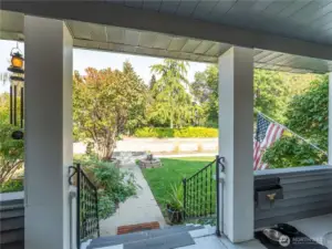 Welcoming covered porch blends historic Tudor charm with functional outdoor living space.