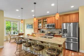 Open concept Kitchen feature Granite Island with Eating Bar, Stainless appliances, and Gas range.