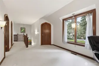 Upstairs hallway - middle door leads to a room with a window that currently has shelves for storage, but could easily be used as an office.