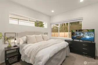 Primary bedroom with en-suite bath overlooking the private backyard