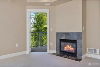 The living room has a natural gas fireplace insert with the slate surround. There is access to a deck that also opens to the primary bedroom.