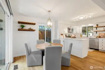 Dining area with slider and window to side yard.