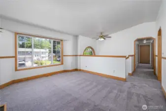 Living area with a large window and ceiling fan. Fresh interior pain and brand new carpet!