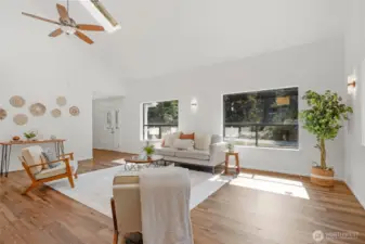 Large living area with vaulted ceilings with skylights.