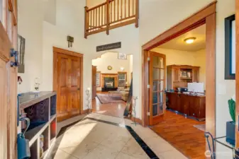 This gorgeous entry way features travertine and marble flooring and an adjacent office space with french doors.