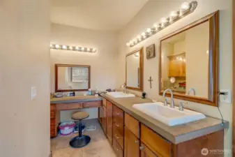 Primary en suite bath with double sinks and built in makeup application space, including additional storage around the corner.