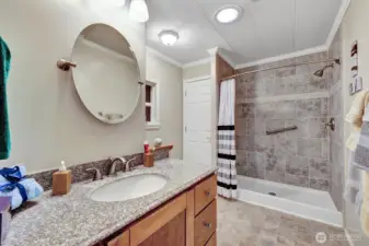 Custom floor to ceiling tile step in shower. Grab bars for your safety. Linen closet for all bath necessities. Custom vanity. Half wall separation for the commode area.  Solar tube brings in natural lighting day and night. Walker or wheelchair accessible.