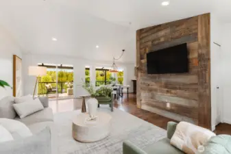 A reclaimed wood accent wall with mounted TV brings texture and warmth, grounding the modern design with rustic charm. Movie nights just got a serious upgrade.