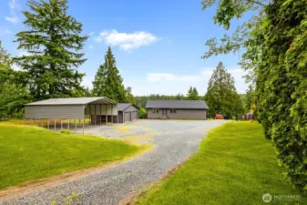 This oversized gravel driveway offers ease of access and ample parking, while the detached two-car garage and large carport provide perfect storage for your boat, RV, or weekend gear.