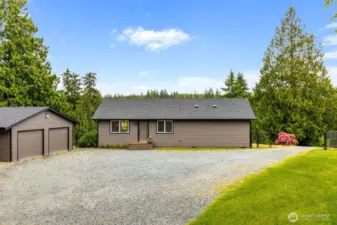 This inviting entry greets you with low-maintenance landscaping and a spacious front area—ideal for greeting guests or simply enjoying your private escape surrounded by towering evergreens.