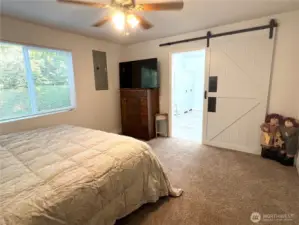 Primary bedroom with barn door to primary bathroom