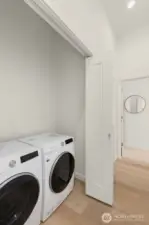 Dedicated laundry room with upper cabinetry and full-size washer/dryer.