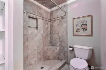 Primary tiled shower and heated flooring.