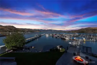 Looking from the upper level in the evenings overlooking the patio with fire pit and marina.