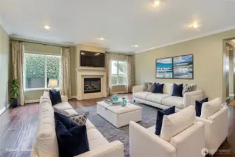 Great room view, LOVE the hardwood floors and crown molding in this home. One of two fireplaces here, large windows, entry to your right. ***Virtually Staged***
