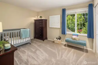 First of three additional spacious bedrooms upstairs looks to the beautiful, private backyard.