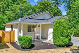 Adorable covered front porch with fresh landscaping out front.