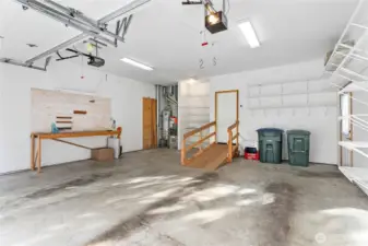 Oversized garage with workbench and ramp for no stairs entry.