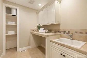 Laundry room with a laundry shoot from the upstairs bath. There's another large storage closet on the left.