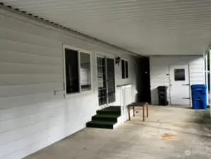 Car port with entrance to house and hobby/storage space