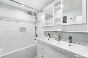 The remodeled primary bath features double sinks, medicine cabinet storage, and a skylight.