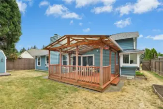 The fully-fenced backyard has plenty of flat grassy space to run and play. Don't miss the raised garden beds that run along the side of the home.