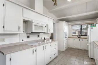 The kitchen features soaring vaulted ceilings