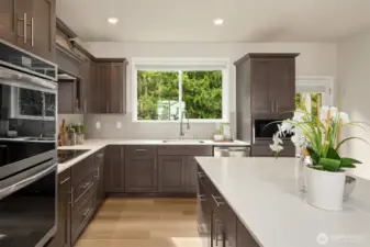 Kitchen with custom cabinetry that overlooks gorgeous backyard and greenspace beyond.