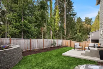 Perfectly manicured backyard with a patio for grilling and enjoying the birds and serenity of the greenery beyond. Level backyard extends to a large side yard with room for garden and more.