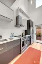 Double height loft ceilings in the kitchen with a large vertical  window above.