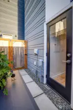 The gated back patio area with access to the kitchen. It has an electrical outlet and a hose bib. A great spot to have a barbeque for grilling right off the kitchen.