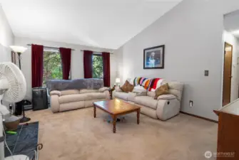 Spacious living room facing 87th St, featuring vaulted ceilings that enhance the open, airy feel.