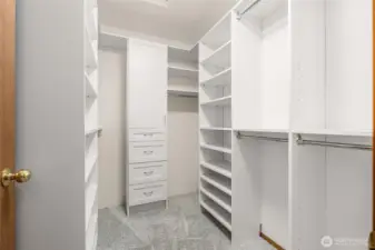 Primary walk in closet with system for the organized at heart.