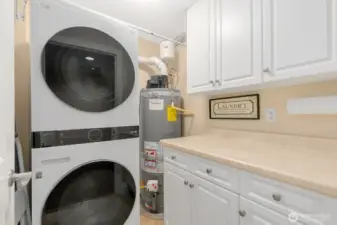 Spacious laundry room offers functional countertop with built in cabs.