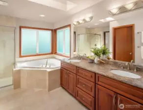 Primary Bathroom features double vanity, granite countertops, undermounted sinks, large jetted tub, shower, ceramic tile walls/floors, etched glass windows, recessed ceiling lights and private toilet room.