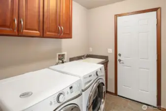 Utility Room features front-load Whirlpool Duet washer & dryer, deep utility sink & vanity with quartz countertop, and upper cabinets.