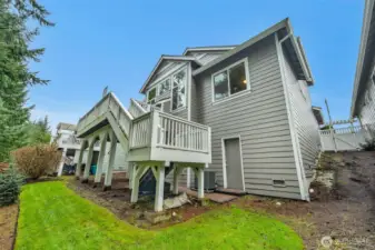 nice backyard and deck overlooking the 18th green. Notice door to large roughed in basement with workshop and half bath.