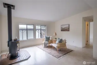 Enter the home from the front into the living room with large windows and a gas stove for year round comfort.