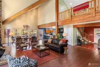 Great room boasts soaring ceiling with wood beams.