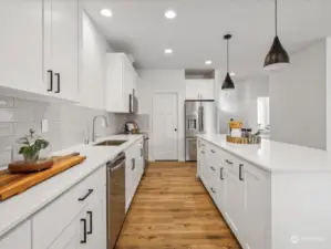 Kitchen with quartz countertops, tile backsplash, and abundant cupboards.