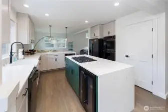 Amazing kitchen has island with storage on both sides and beverage fridge, double ovens and pantry.