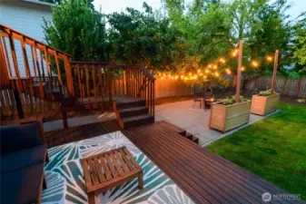The fully fenced yard features a spacious deck, fruit trees, and raised garden beds—perfect for relaxing or entertaining.
