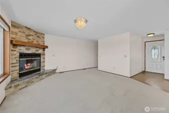 Living room with view of the entry way and stone fireplace