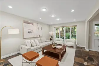 Just off the entry is the comfortable living room - complete with floor to ceiling windows and recessed lighting. The first floor is all one level surface of California Gold slate flooring material. The dated "sunken living room" feature was removed during renovation.